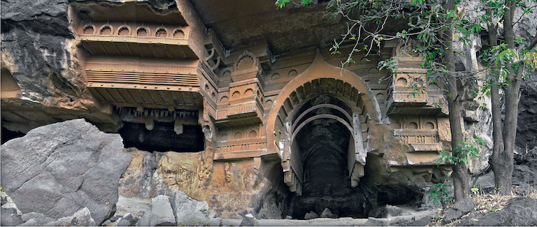 Cave at Kondane: The wooden window and ribbing, showing the wood craftsmanship of fifteen centuries ago. Also visible are the beams and rafters cut in stone in imitation of wood structures of that time. The wooden ribbing in the chaitya caves serves no structural purpose but was put there because of the ingrained wood construction techniques prevailing at that time.